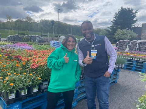 Simply Set Merchandisers in a group photo with their displayed flowers in the background