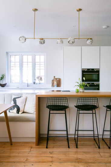 a kitchen with white cabinets and black stools