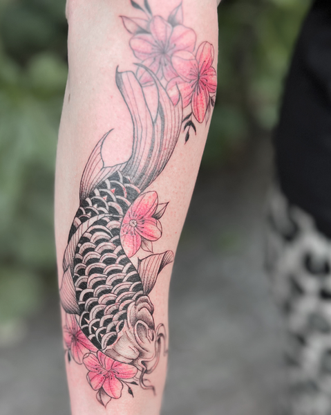 Japanisch inspiriertes Tattoo eines Koi-Karpfens auf dem Arm mit markanten schwarzen Schuppenmustern und leuchtend roten Kirschblüten, gestochen bei Neuanstich in Horneburg Landkreis Stade..