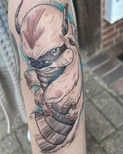 Detailreiches Anime-Tattoo der fliegenden Bison-Figur Appa aus Avatar mit blauem Hintergrund auf dem Unterarm, umgesetzt bei Neuanstich im Raum Stade.
