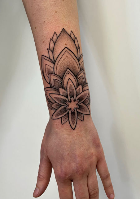 Elegantes Ornament- und Mandala-Tattoo am Handgelenk. Die feine Kombination aus klaren Linien (Linework) und sanften Dotwork-Verläufen schmiegt sich perfekt an die Anatomie des Unterarms an – ein individuelles Design von Neuanstich Landkreis Stade.