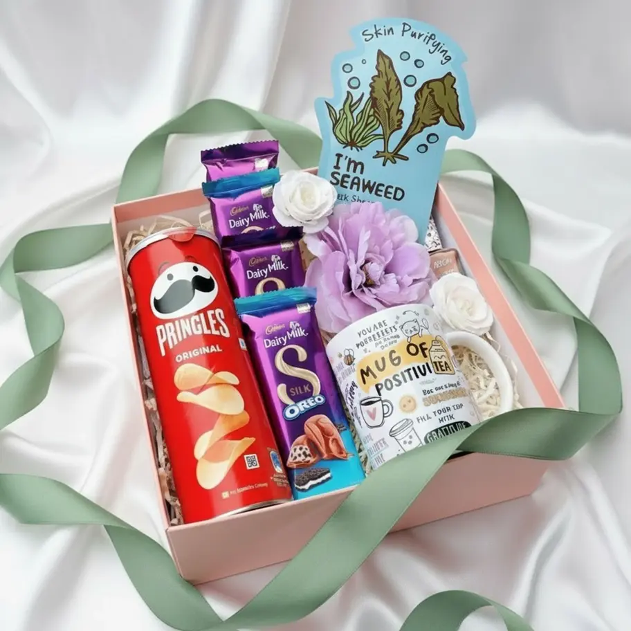 Pink gift box with mug, snacks and self-care items