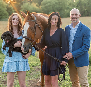 Picture of business owner megan Yoder, standing next to her husband and daughter and a horse.