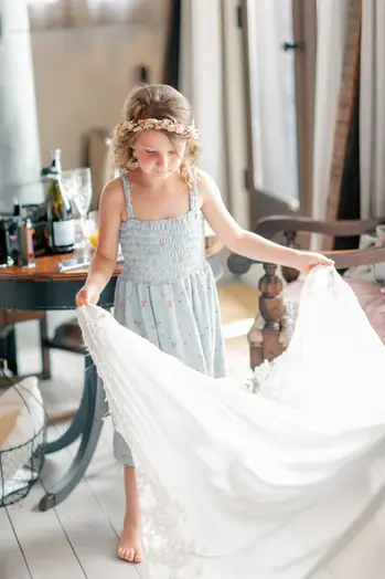 Flower girl helping bride get ready for a summer wedding in Keating Farm, Nanaimo, British Columbia