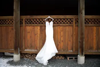 white wedding dress hanging on a wooden fence in fraser river lodge agassiz british columbia 