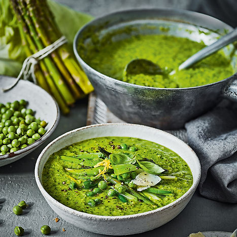 spring detox green soup with peas and fresh herbs in a bowl. Healthy green detox soup for spring cleansing.