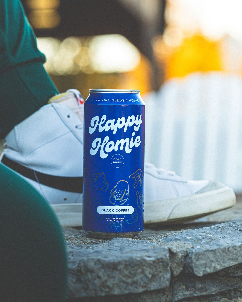 Happy Homie Cold Brew can placed on a stone surface with sneaker in the background.