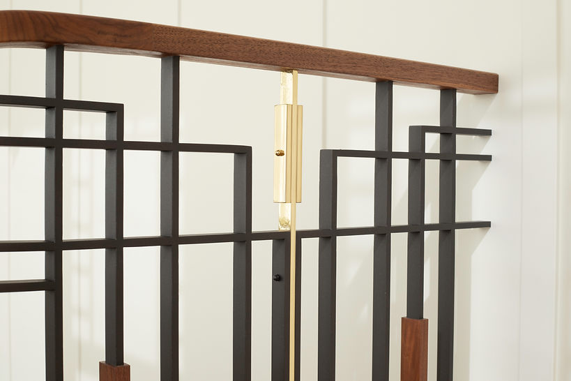 Close-up of the custom steel, walnut and brass stair guardrail.