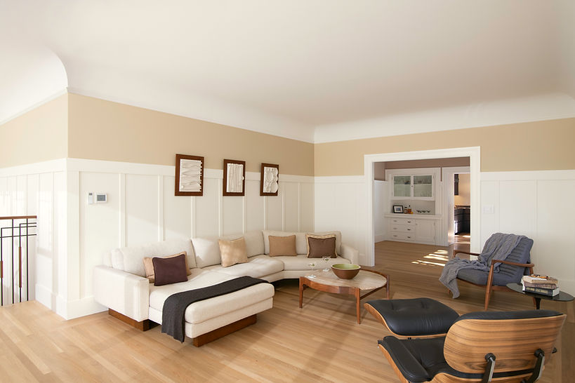 The sun-drenched living room features Craftsman paneling, cove ceilings and oak floors.