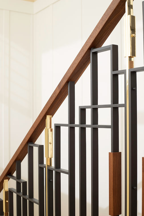 Close-up of the custom steel, walnut and brass stair guardrail.