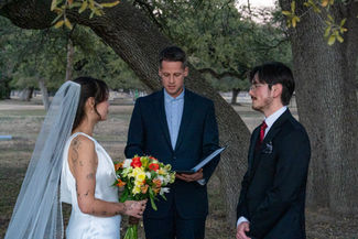 Couple exchanging vows during outdoor wedding ceremony