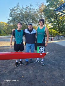 Coach with two rowers in teal uniforms, one wearing bib #53