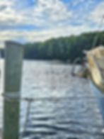 Boat docked at wooden post on lake with trees