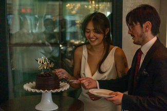Bride and groom cutting chocolate wedding cake.