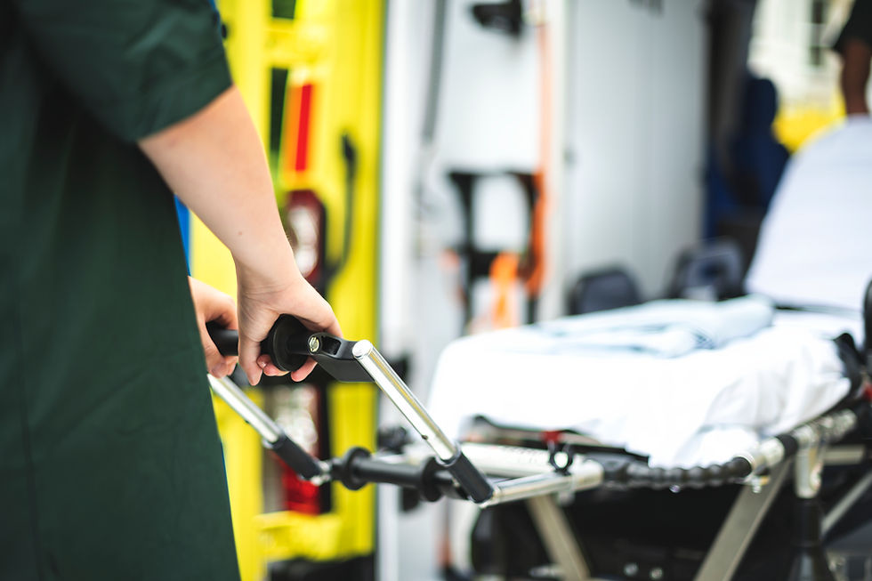 Paramedic pushing stretcher into ambulance