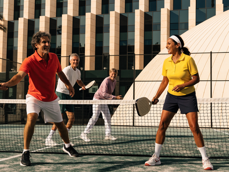 Adults over 45 playing padel together on an outdoor court in Dubai