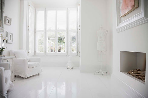 Armchairs and fireplace in elegant, white living room