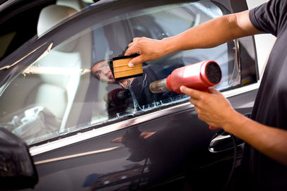 Man installing window tinting on car