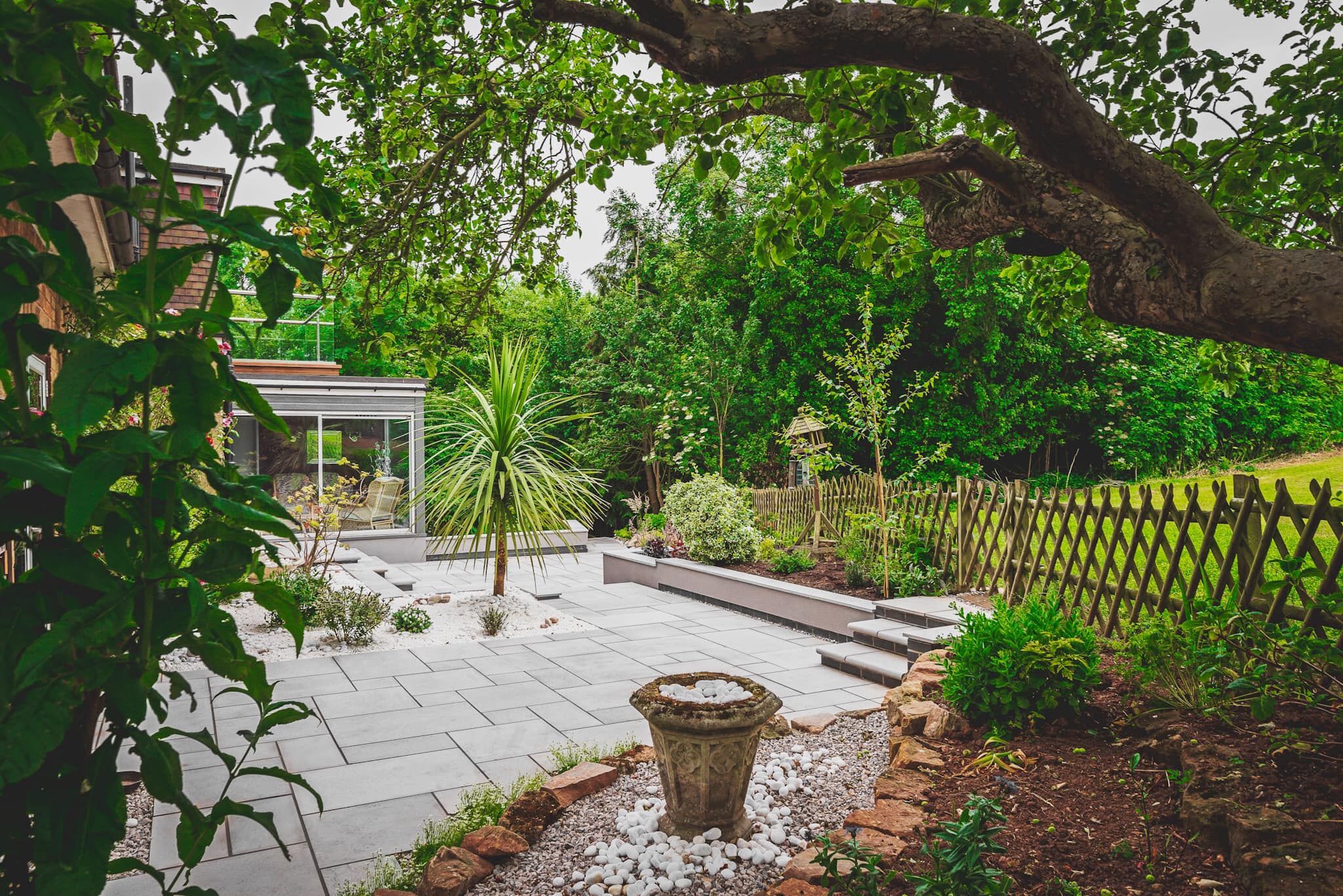 Tree overhanging new patio area with lattice fencing