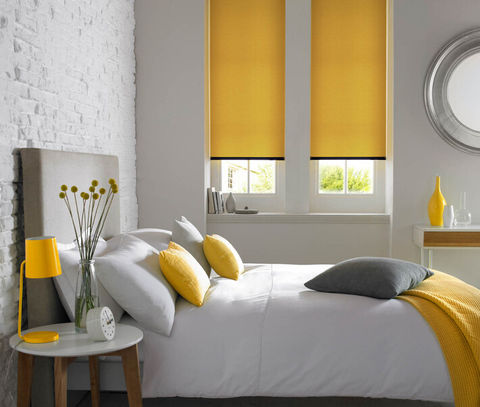 Yellow and grey themed bedroom with large bed, yellow roller blinds and grey and yellow accessories