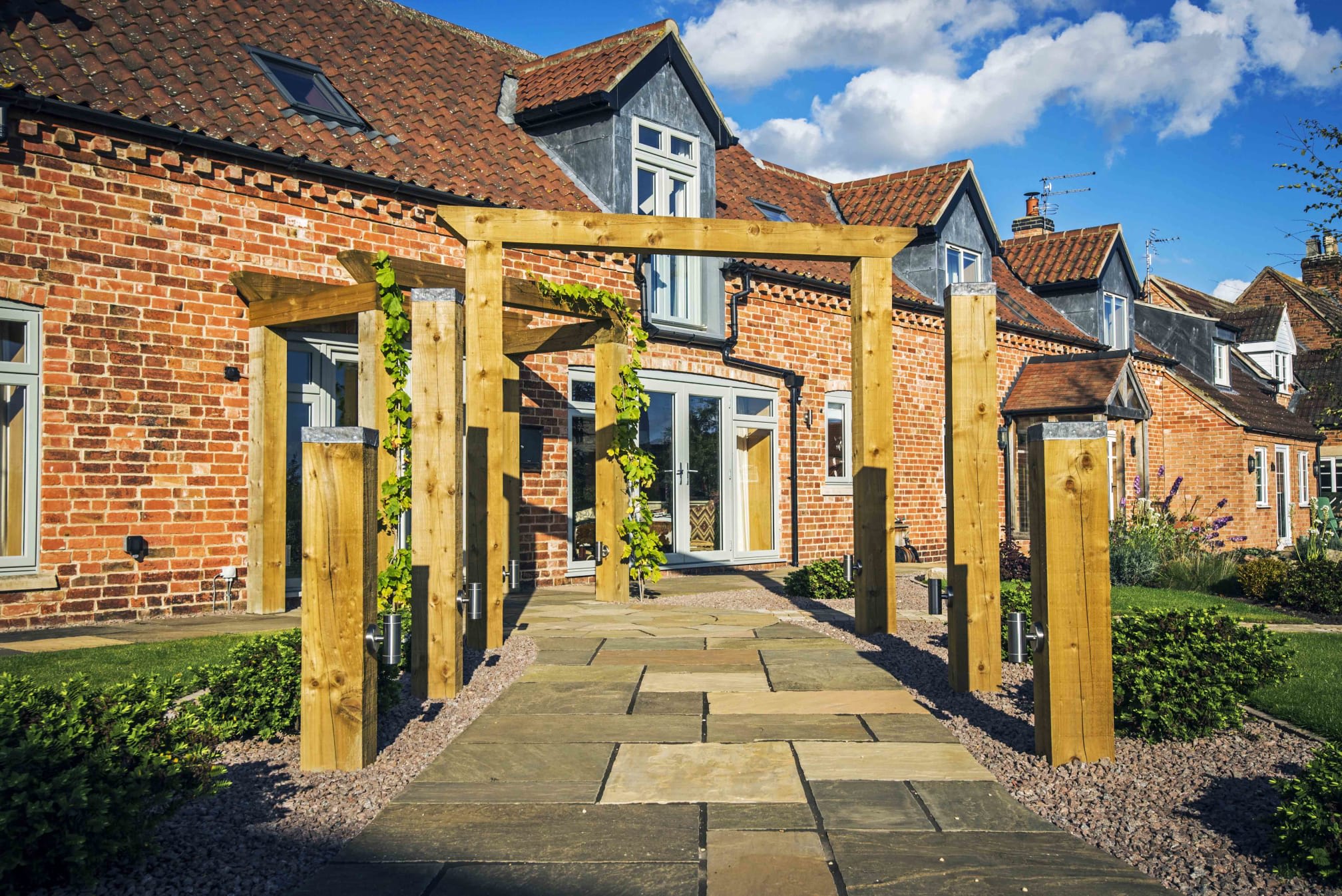 Wooden archway over tiled garden path