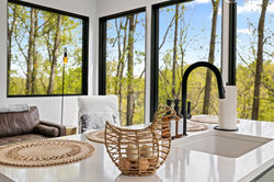Lofty Ledges Hangout Kitchen with contemporary white walls and black window frames. The trees outsid