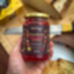 Wild Pantry PowerKraut being held over toast, a loaf of bread and hummus
