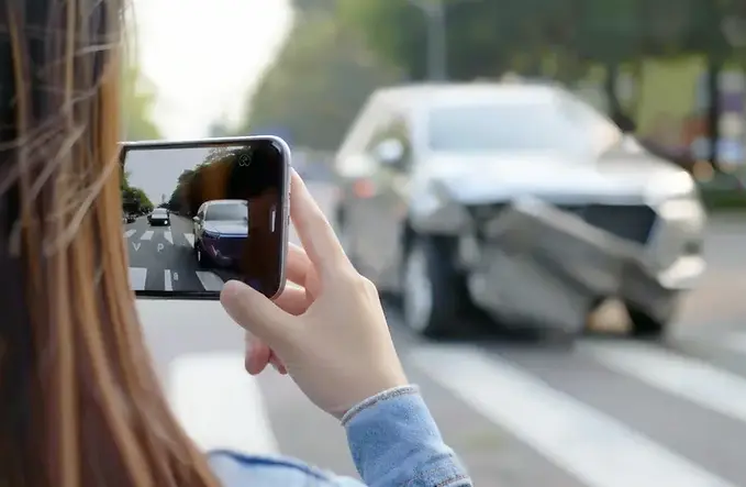 Georgia driver taking photo of crash damage after car accident – collecting evidence for personal injury or insurance claim.