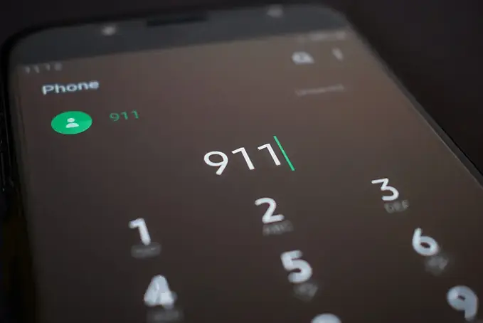 Close-up of smartphone screen dialing 911 – emergency call after car accident or injury in Georgia.