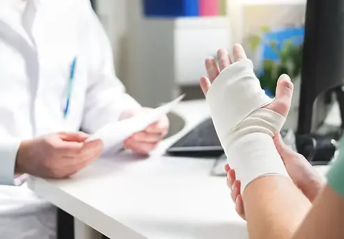 Injury consultation with a personal injury attorney in Georgia – patient with a cast on left hand speaking with a medical professional.