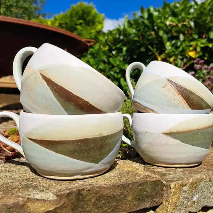 Handmade stoneware cups, generous squat shape with geometric layered glaze in earthy tones brown, green, off-white. Made in Northumberland