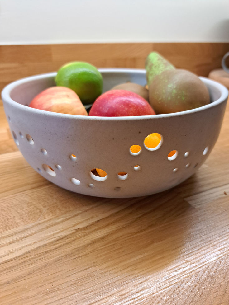 Handmade ceramic fruit bowl with decorative holes pattern in off white glaze
