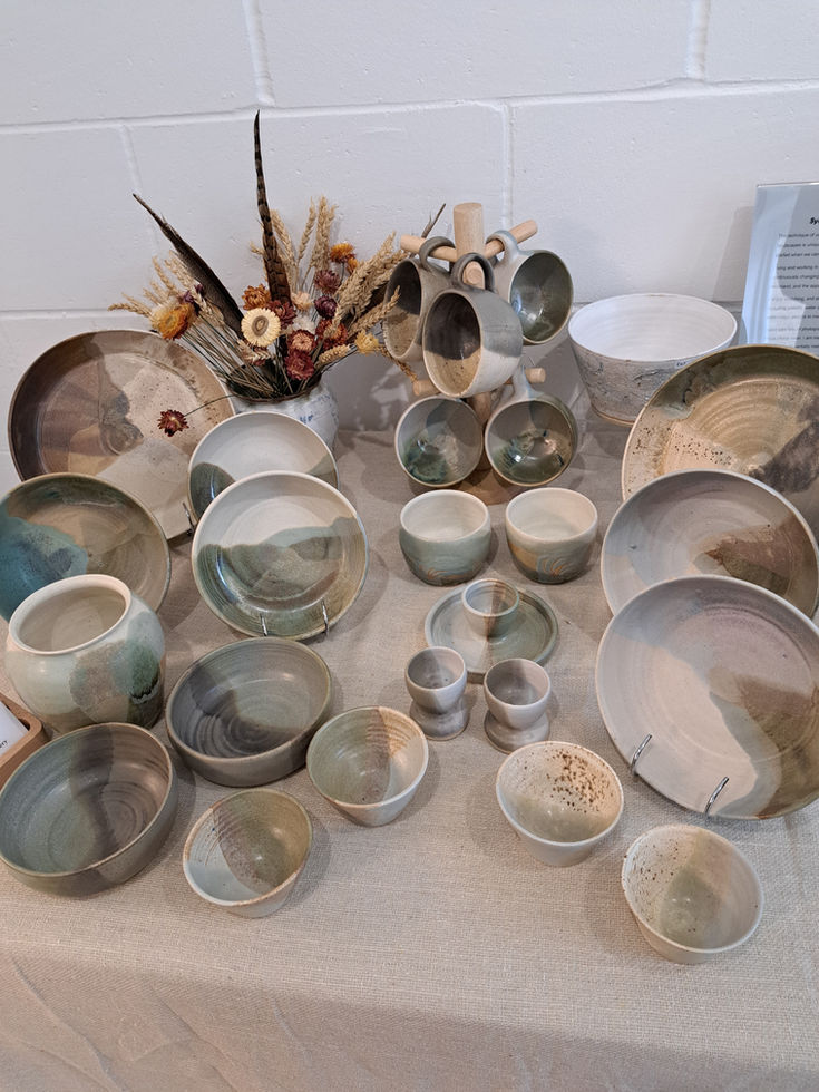 Handmade ceramic plates, bowls, and mugs in earthy tones by Cornerstones Pottery, Northumberland
