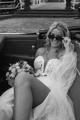 bruid liggend in de auto met boeket