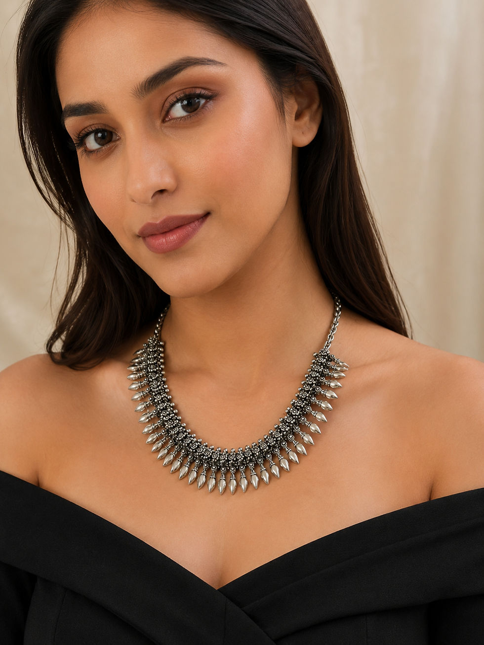 Woman wearing an oxidised silver statement necklace with teardrop charms and a silver chain.