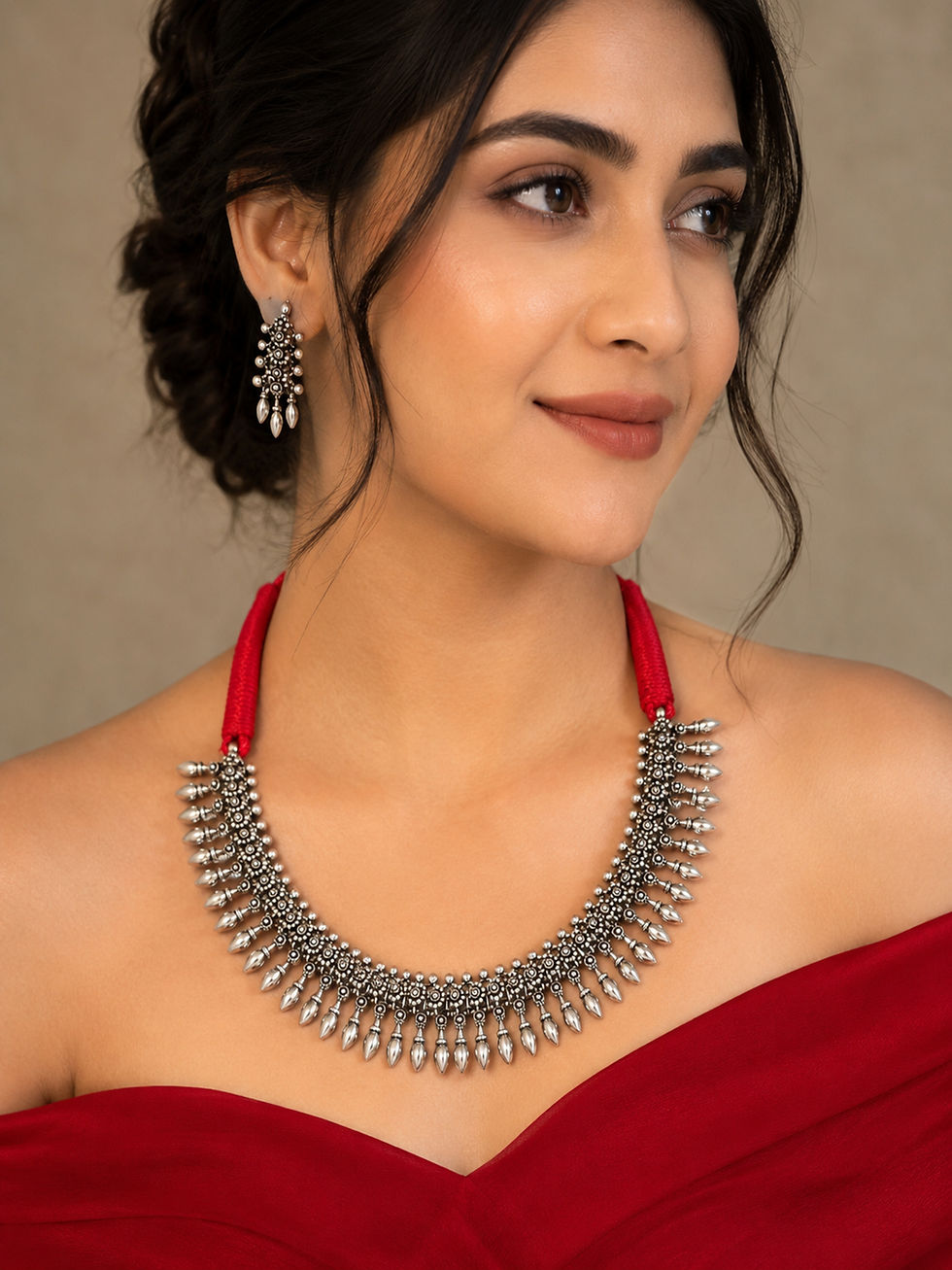 Athizay oxidised silver necklace worn with a red outfit, featuring red thread, detailed silver work and hanging teardrop char
