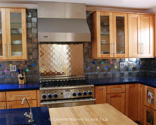 American Made Lightstreams Glass Tile Pink Perfection Jewel Glass accent tile is just one of the patterns used in this whimsical stainless steel kitchen backsplash. Jewel Inlays glass accent tile strands also highlight the kitchen backsplash.