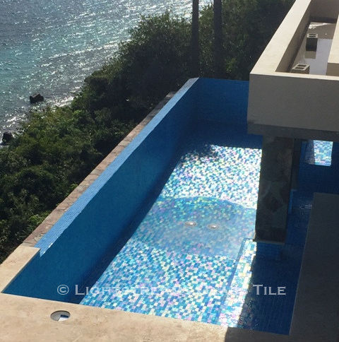 American Made Lightstreams Glass Tile Aqua Blue tile is used as pool tile and spa tile for this all glass tile pool. This photo shows the iridescent tile coloring of Lightstreams reversible tile