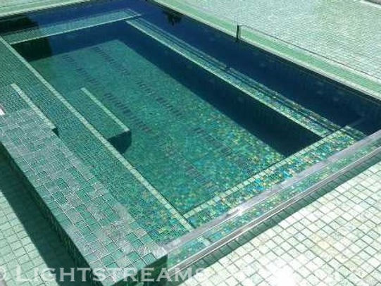 American Made Lightstreams Glass Tile Renaissance Collection Celadon green tile is used as pool tile and spa tile for this all tile pool and all tile spa showing the iridescent tile of Lightstreams signature reversible tile