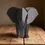 Miniatura: Elefante geometrico grigio scuro su tavolo di legno
