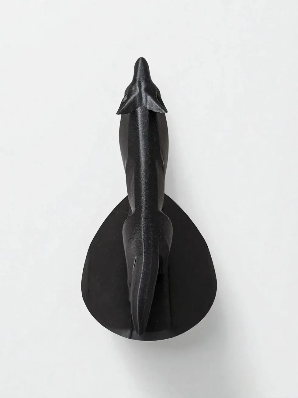 Miniatura: Scultura nera stilizzata, forma allungata, dardo, su sfondo bianco.