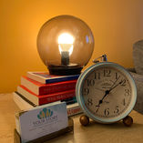 Warm lamp, books, vintage clock, 'YOUR STORY' business card