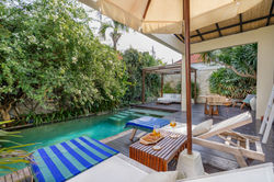 Villa Madu pool deck with sun loungers and umbrella, private villa Seminyak