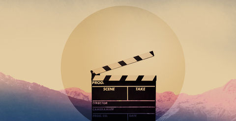 A film clapperboard against a serene mountain backdrop with a large sun. Visible text: "PROD., SCENE, TAKE, DIRECTOR, CAMERAMAN."