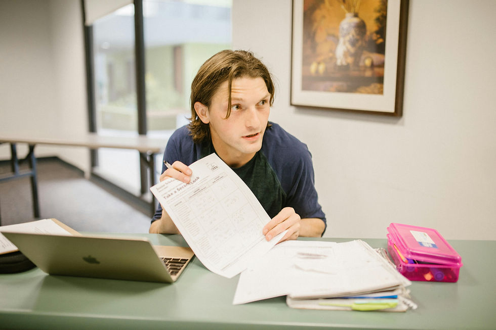 Team leader reviewing an assessment worksheet during a leadership development session, using tools to evaluate performance and build clarity