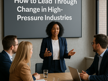 A manager leading a meeting on how to lead through change in high-pressure industries, speaking to three colleagues seated at a conference table with the session title displayed on a screen behind her.