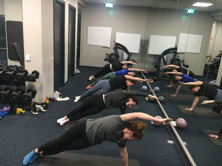 Corporate Pilates group photo side plank exercise