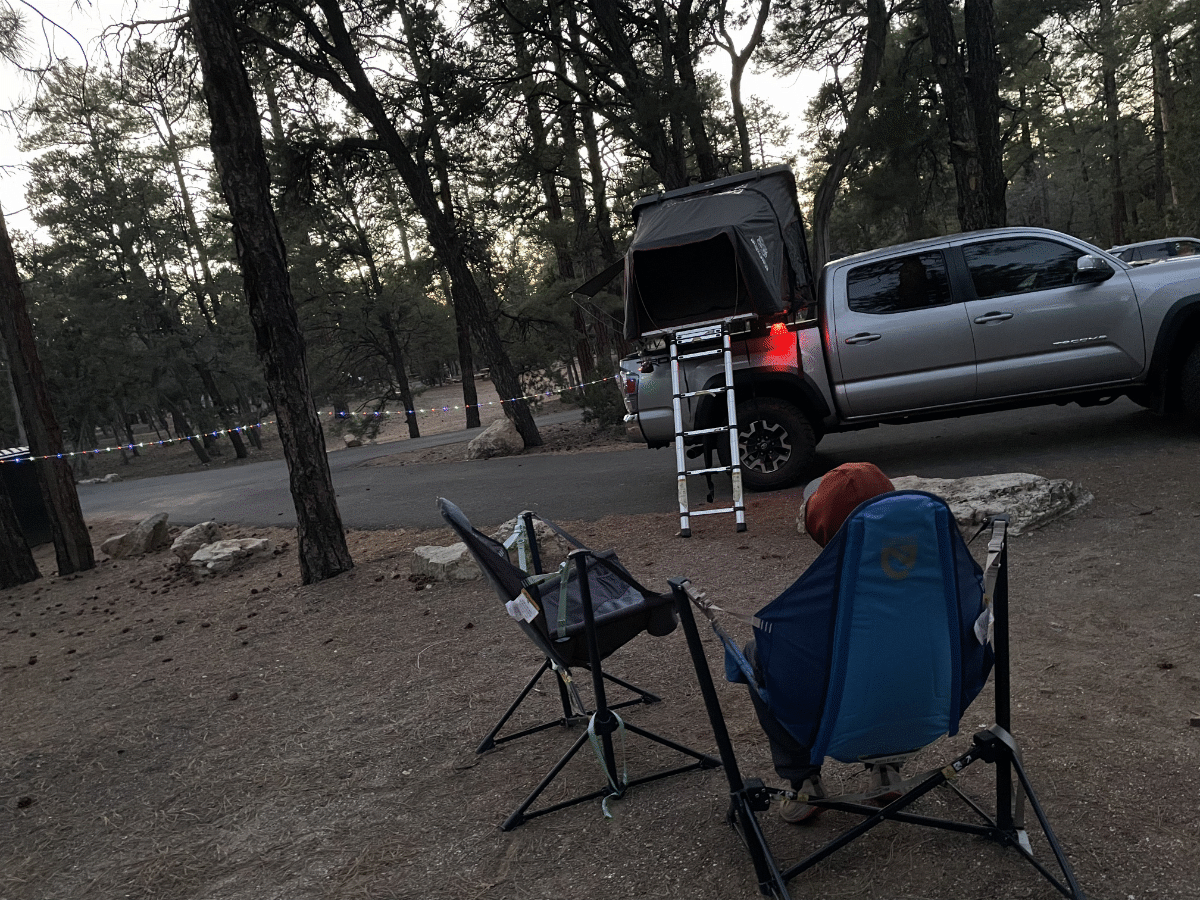 iKamper Skycamp Mini on a 5-foot bed Toyota Tacoma at a campground with two chairs set up - via NVilloria.com 