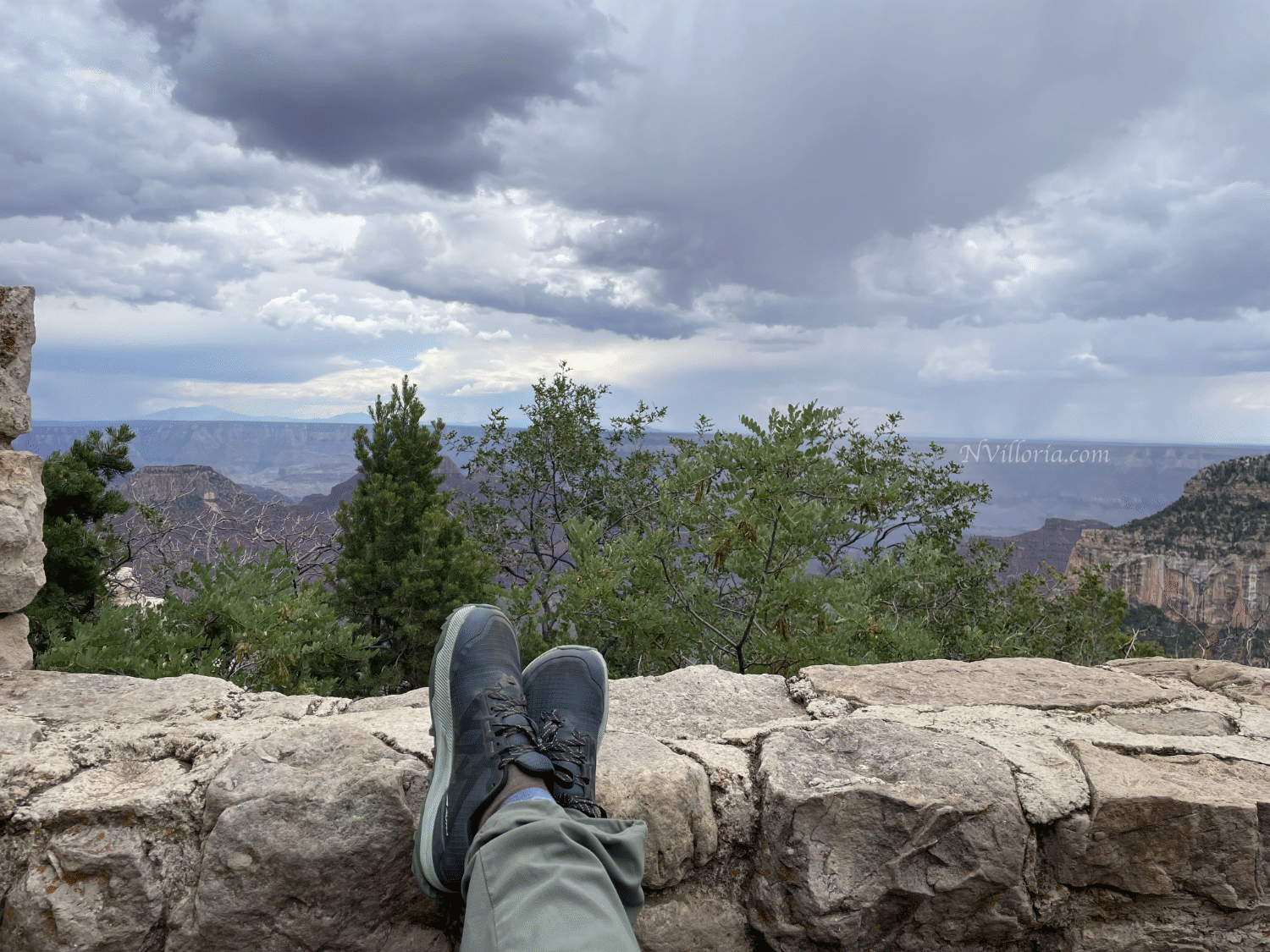 feet up on a stone wall looking out at the views at the Grand Canyon North Rim - via NVilloria.com