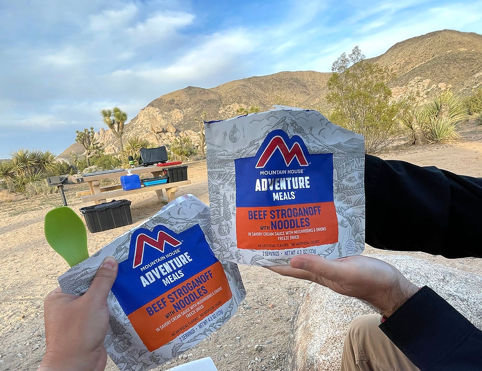 two people holds their hands up and displaying backpacker camp meals.